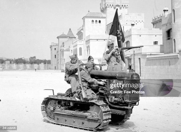 Government troops perched on a tractor in a Barcelona street during the Spanish Civil War.