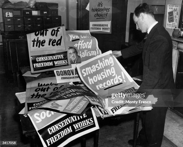 Mr R Marriot, the election agent of the Holborn and St Pancras Conservative Party in London, inspecting election posters in his office before the...