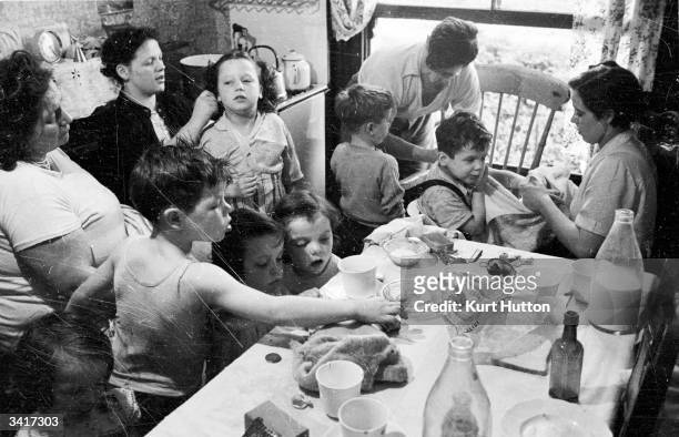 Some of the twenty children of record-breaking mother Elizabeth Hudson, crowding into the kitchen of their London home. Original Publication: Picture...