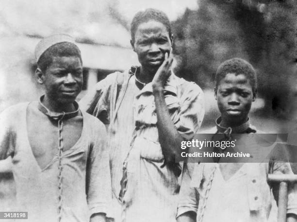 Three Abyssinian slaves in iron collars and chains.