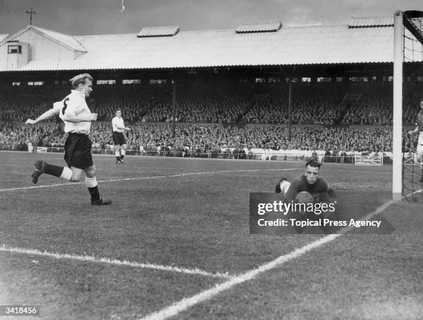 Canadian national goalkeeper, Hanson, saves from the on rushing England inside right, Wilf Mannion, as the Touring Canada side play England's World...