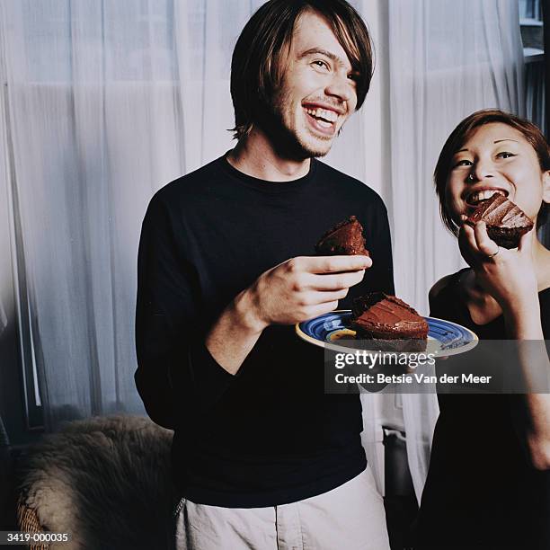 young couple eating cake - couple chocolate stock-fotos und bilder