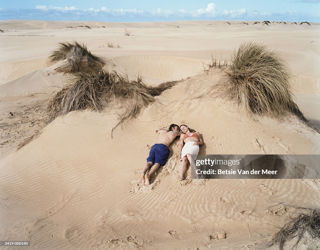 Couple Relaxing on Sand Dune
