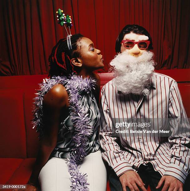 couple at christmas party - black women kissing white men stock pictures, royalty-free photos & images