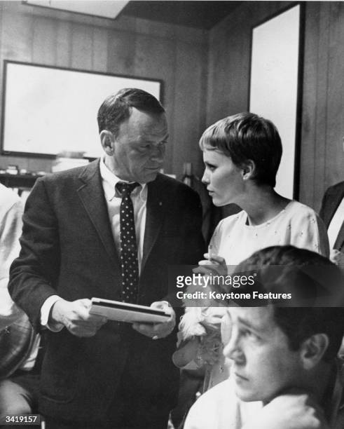 Film actor and popular singer Frank Sinatra chats with his young wife, actress Mia Farrow during a break in a recording session at Hollywood's Sunset...