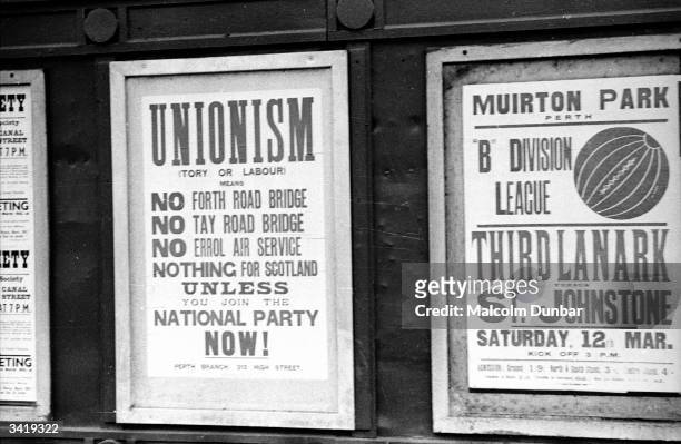 Posters for the Scottish National Party and a football match, Third Lanark versus St Johnstone vie for attention on a wall in Perth, the 'Fair City',...