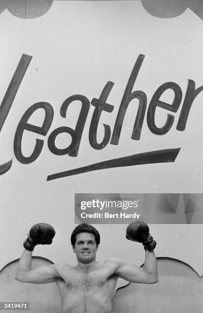 British boxer Freddie Mills shows how tough and hard wearing he can be as he promotes leather at the National Leather Week Exhibition at Earls Court....