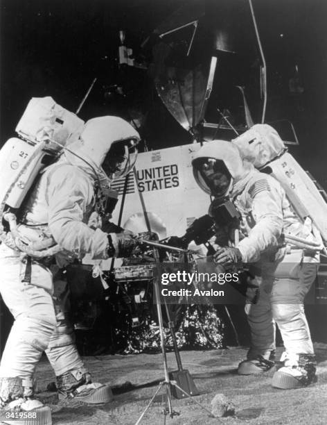 Edwin 'Buzz' Aldrin uses a scoop to collect samples of the surface while Spacecraft Commander Neil Armstrong photographs him during training at the...