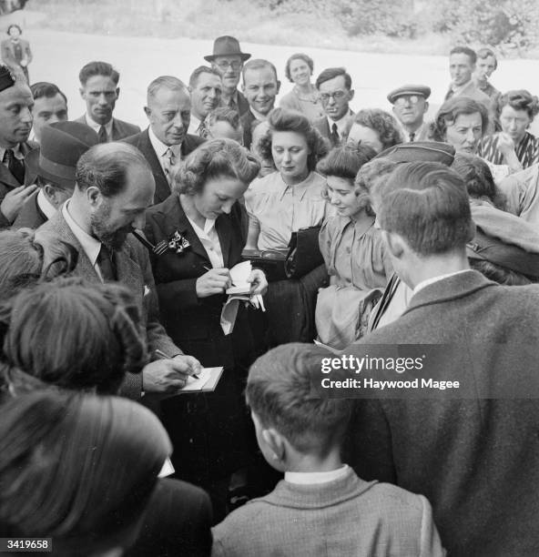 American actress Constance Cummings, who is married to Lieutenant Ben Levy, writing autographs for constituents during her husbands election campaign...