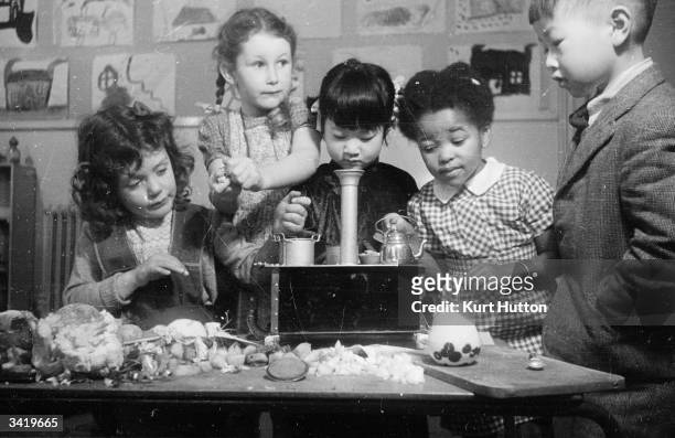 Children baking at the Fortis Green nursery school. The United Nations Organisation, Organised children of different nations to cook for a party at...
