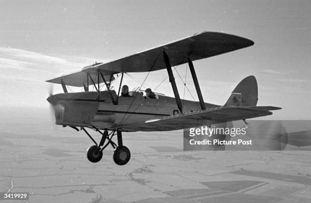 The British actress Valerie Hobson and actor David Tomlinson who takes both hands off the controls, in a Tiger Moth aeroplane during a flying lesson....