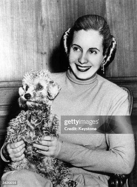 Former actress and wife of the Argentinian president, Eva Duarte Peron , popularly known as 'Evita', holding her pet dog at her home in Olivos, a...