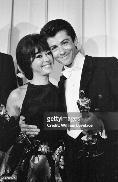 Actress and singer Rita Moreno and American actor George Chakiris both holding their Oscars at the award ceremony in Hollywood.
