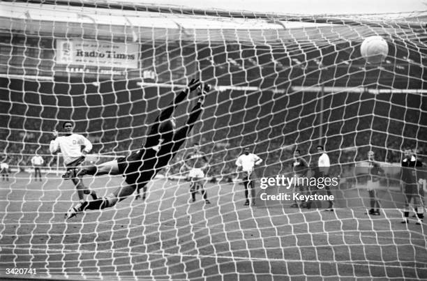 Portugal's Eusebio hammers his penalty kick past Russia's Lev Yashin, to put his country in the lead during the World Cup third place play off game...
