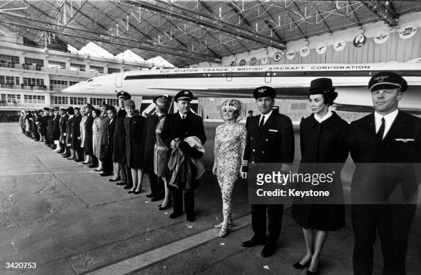 Pilots and hostesses from airliners which have ordered Concorde, the world's first supersonic airliner, stand in front of the plane at the official...
