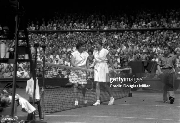 American tennis players Louise Brough and Margaret du Pont shaking hands on the court after the women's singles final at the Wimbledon Lawn Tennis...