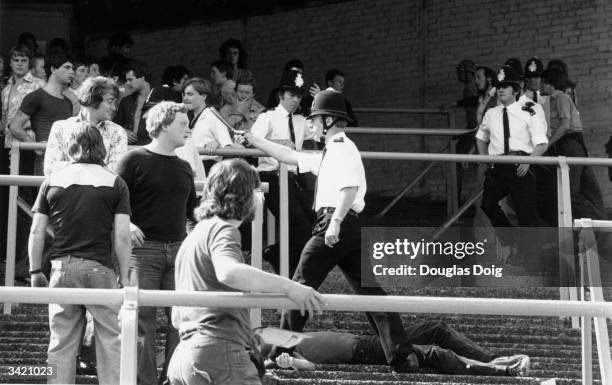 Police at the scene of a disturbance on the terraces during a football match between Millwall and Newcastle United.