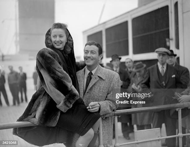 Married American actors Barbara Stanwyck and Robert Taylor on board a ship.