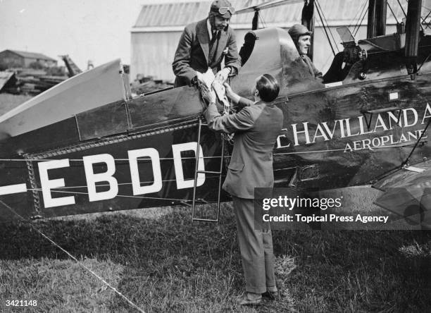 Aviator Alan Cobham in his De Havilland D.H.9C talks to his assistants. He frequently used a De Havilland to map out 'route proving' flights many of...