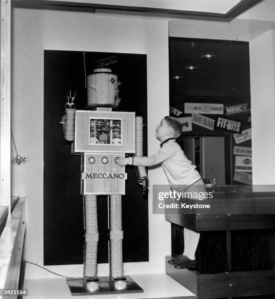 Six-year-old Neil Dixon of Cheam playing with a giant Meccano robot at the show rooms of Lines Bros Ltd, Edgware Road, London, where the first...