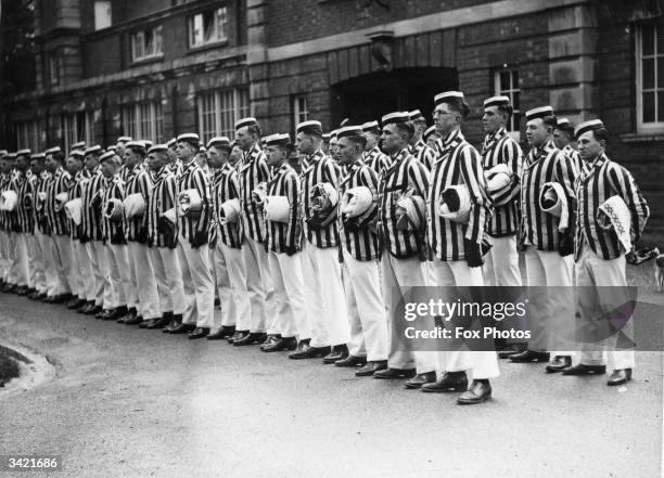 Officer cadets at Sandhurst College in their striped blazers and caps and all carrying a towel roll under their arms.