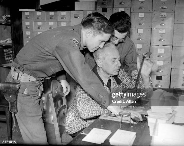 Hitler's photographer Heinrich Hoffmann inspecting evidence during the Nuremberg War Crimes Trial.