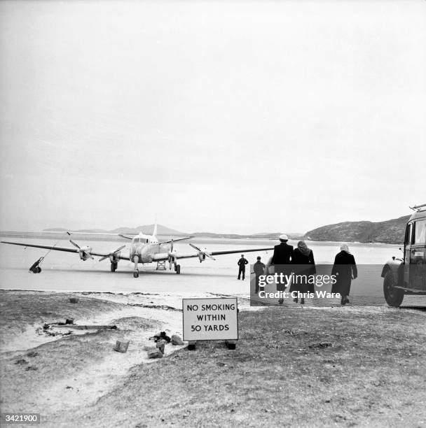 Passengers arriving at Barra airport, Britain's smallest, in the Hebrides off the West Coast of Scotland. Barra, named after St Barr, is the most...