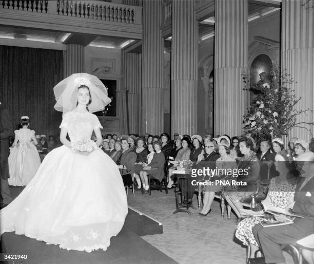 Princess Margaret watching a model wearing a crinoline wedding dress during her visit to the Charity Junior Fashion Show at mansion House in London.