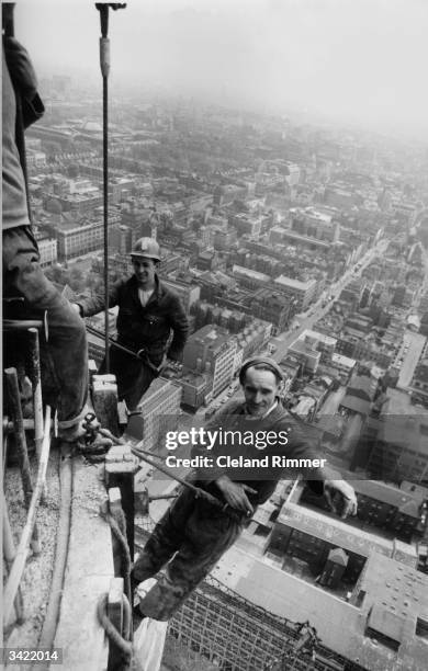 Two workmen suspended from the Post Office Tower, London during its construction.