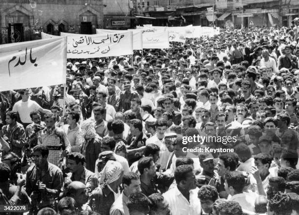 Thousands of people including armed Palestinian guerillas marching through the centre of Amman, Jordan, calling for a Holy War to exact revenge for...