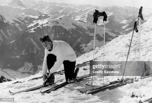 Karim Al Hussaini Shah, Aga Khan IV, fastening a ski during a skiing trip in Kitzbuhel.