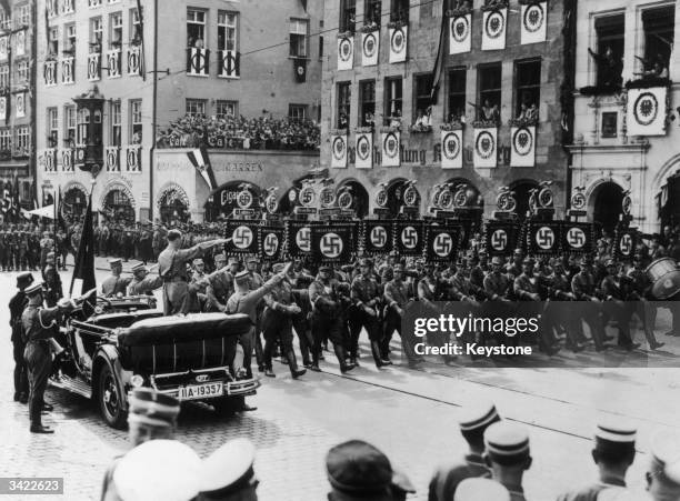 German dictator Adolf Hitler salutes Nazis as they march past during a parade in Nuremberg.