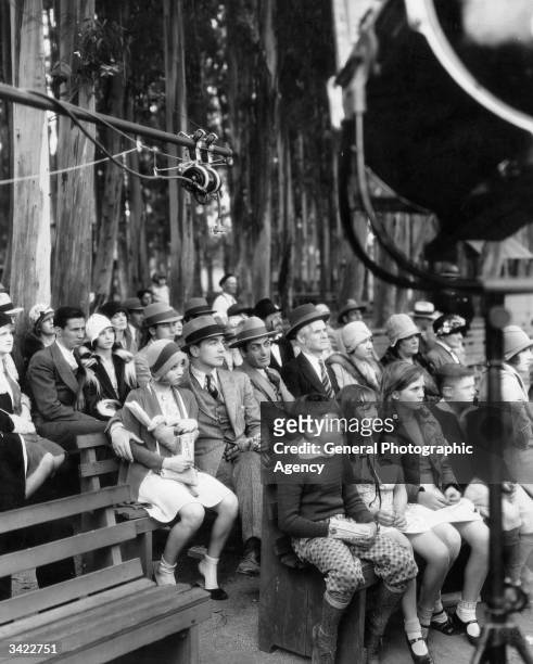 Charles Delaney and Alice White sit amongst the crowd in a scene from the Warner Brothers musical 'The Girl From Woolworths'.