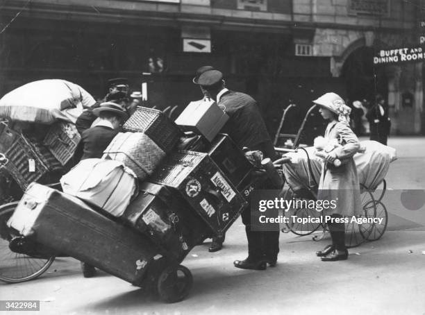 Porters helping holidaymakers with their luggage at Waterloo Station, London.