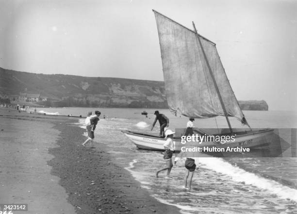 Boat pulls onto the beach at Sandsend, near Whitby, North Yorkshire.