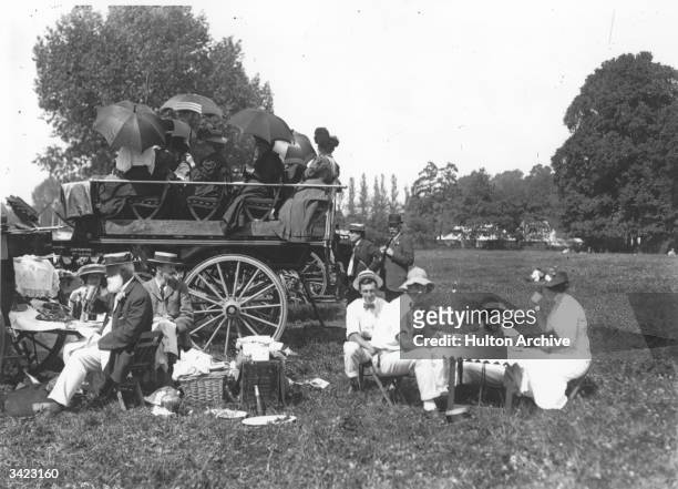 Visitors to Henley Regatta relax over a picnic lunch.