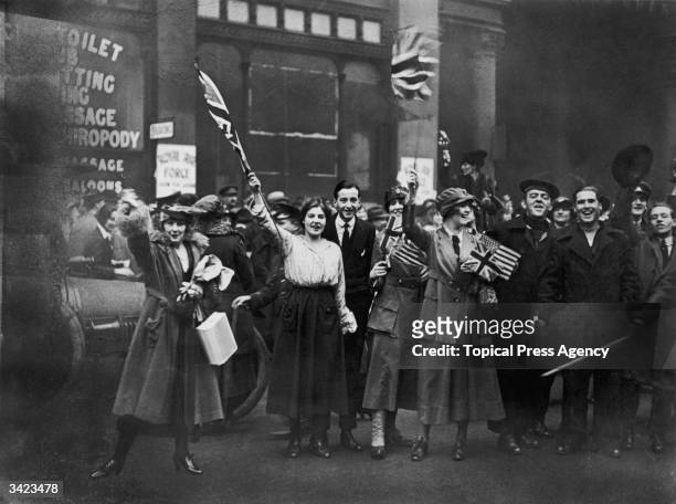 Servicemen and women and civilians celebrating the Armistice ending World War I, UK, 11th November 1918.