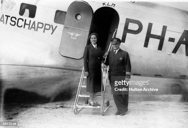 Miss van Leeuwen, a KLM air hostess, with Commander Duimelaar at the entrance to a KLM plane.