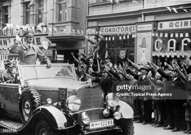 Adolf Hitler is greeted with the Nazi salute as he heads a convoy through Sudetenland, which had become part of the Third Reich after the Munich Pact.