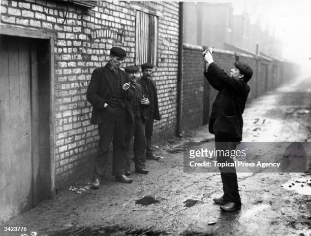 Miner takes great interest in his pigeon during the miners' strike in Wigan.