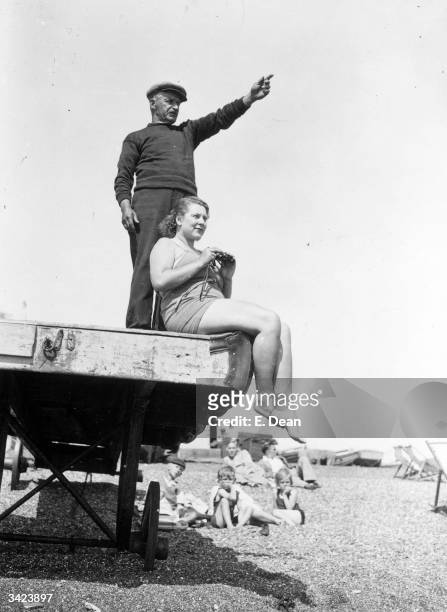 Standing on the beach at Dover, trainer Charles Cole points in the direction of France to US swimmer Eva Morrison, who plans to swim the English...