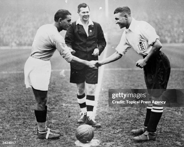 Captains shake hand at the start of a football match between Italy and England.