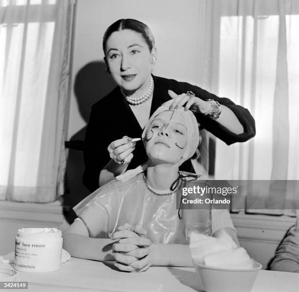 Beauty expert Helena Rubinstein illustrating the shape of the basic lines on the face so that make-up can be applied to flatter individual contours.