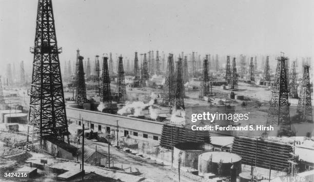 An oilfield of rotary derricks in the USA. The building in the foreground is a gasoline extraction plant.