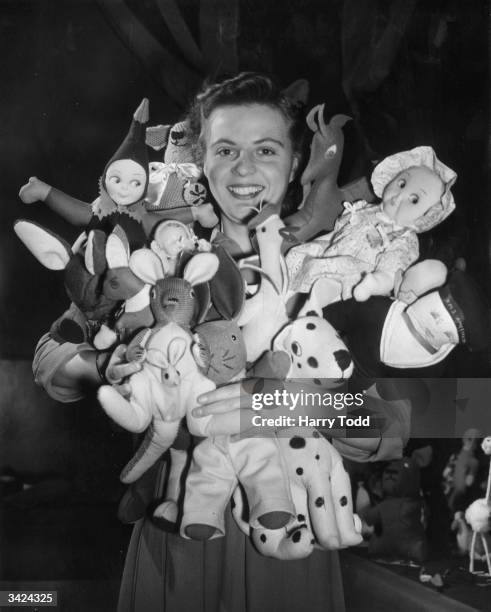 British Railways telephone operator, employed by the Western Region Central Enquiry Bureau at Paddington, holding some of the toys made by colleagues...