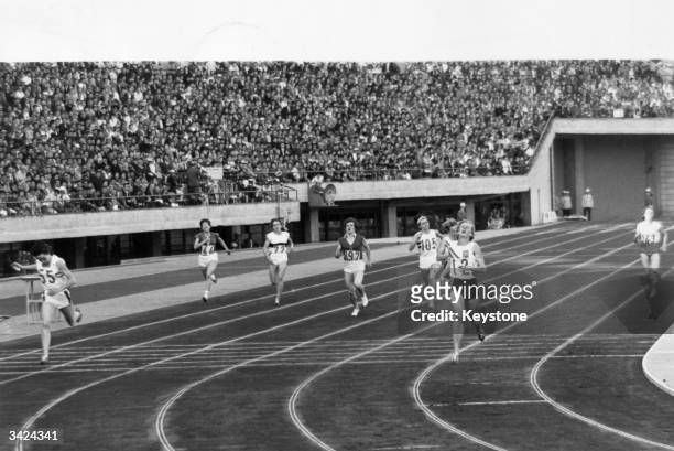 Betty Cuthbert of Australia crosses the finish line to win the 400 metres final at the 1964 Tokyo Olympics. Ann Packer of Great Britain won the...