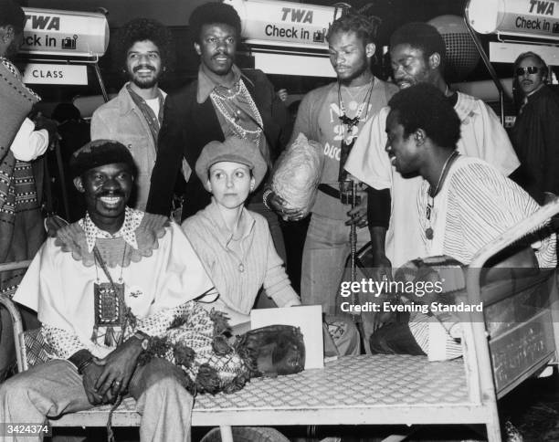 Pop group Osibisa waiting with Caroline Thompson to check onto a flight at an airport. The group, who were formed in London in 1969 by three Ghanian...