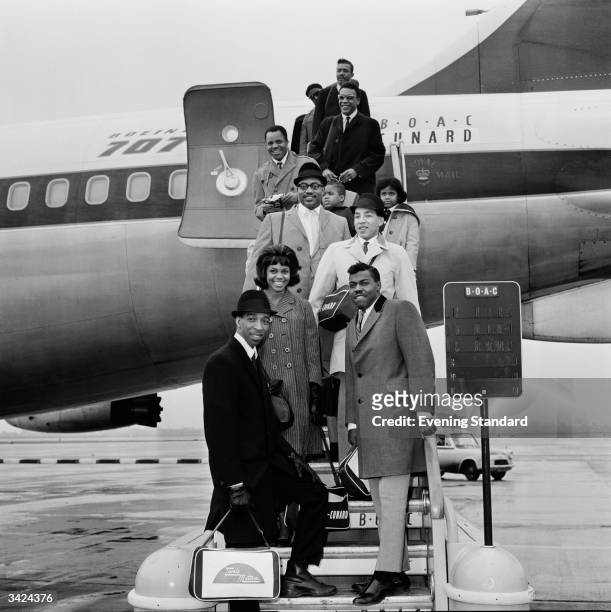 Soul pop singer and songwriter Smokey Robinson, front, and his band The Miracles, who include Smokey's wife Claudette, disembarking from an...