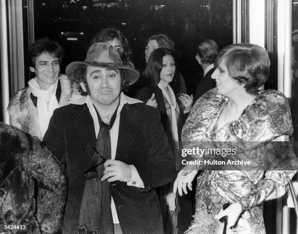 The English composer, lyricist and dramatist Lionel Bart clowns, to the amusement of Angie Bowie, wife of singer David Bowie, at the premiere of...