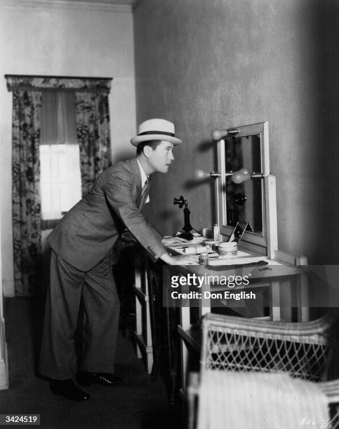 American comic actor Jack Oakie , real name Lewis Delaney Offield, taking a peek at his image in the mirror of his dressing room before going to work...